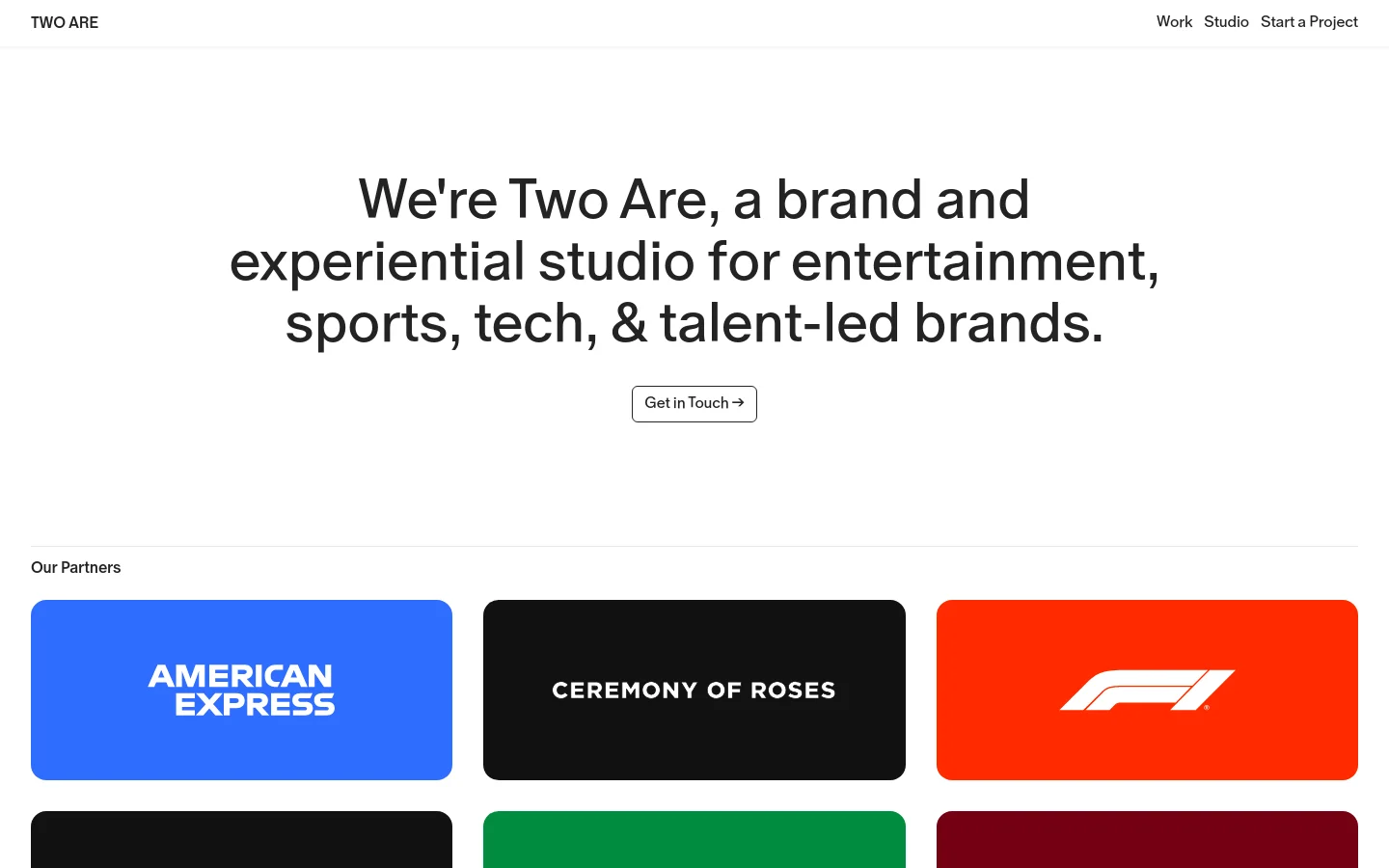 The desktop version features a clean, minimalist white background with large black typography centered in the hero section. A 'Get in Touch' button sits below the main headline, followed by a grid of colorful rectangular tiles displaying partner logos like American Express and F1.