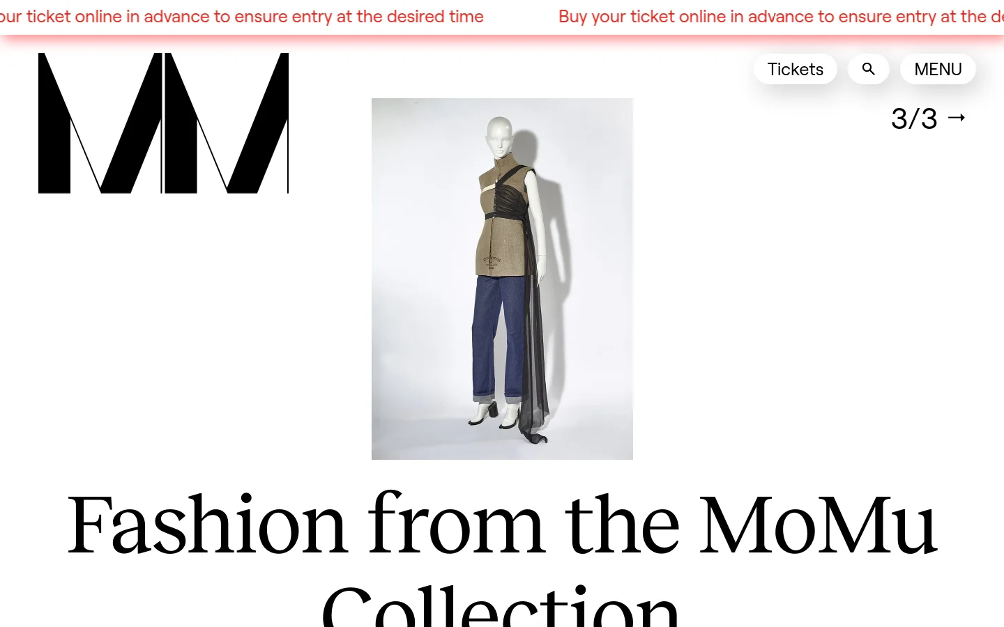The desktop homepage features a minimalist white background with a large black 'MoMu' logo and a prominent hero image of a mannequin wearing a structured beige and black garment. A large serif headline reads 'Fashion from the MoMu Collection' below the image, with a top navigation bar containing 'Tickets', a search icon, and a 'MENU' button.