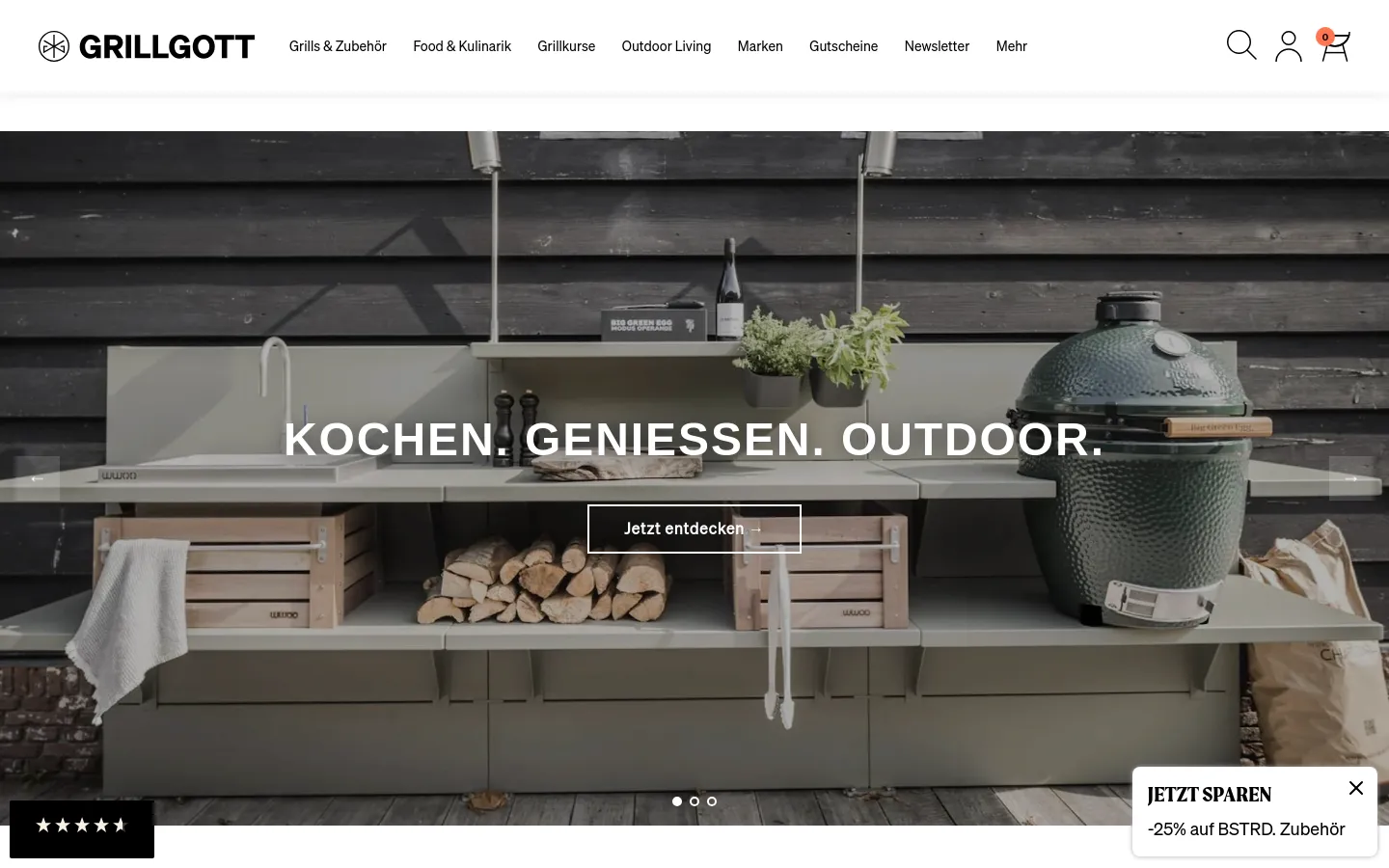 The desktop homepage features a wide hero image of a modern, sage-green outdoor kitchen module set against dark wood siding, featuring a Big Green Egg grill and wooden storage crates. Centered white text reads 'KOCHEN. GENIESSEN. OUTDOOR.' above a 'Jetzt entdecken' call-to-action button. The navigation bar at the top includes the Grillgott logo, various product categories, a search icon, and a shopping cart.