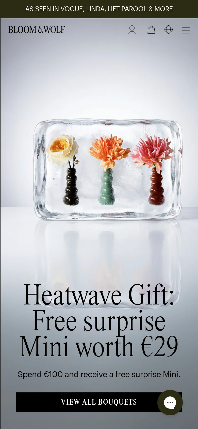 The mobile version presents a vertically stacked layout centered on the hero image of flowers in ice. The 'Heatwave Gift' headline and 'VIEW ALL BOUQUETS' button are positioned below the image, and the navigation is condensed into a hamburger menu icon alongside user, bag, and language icons.