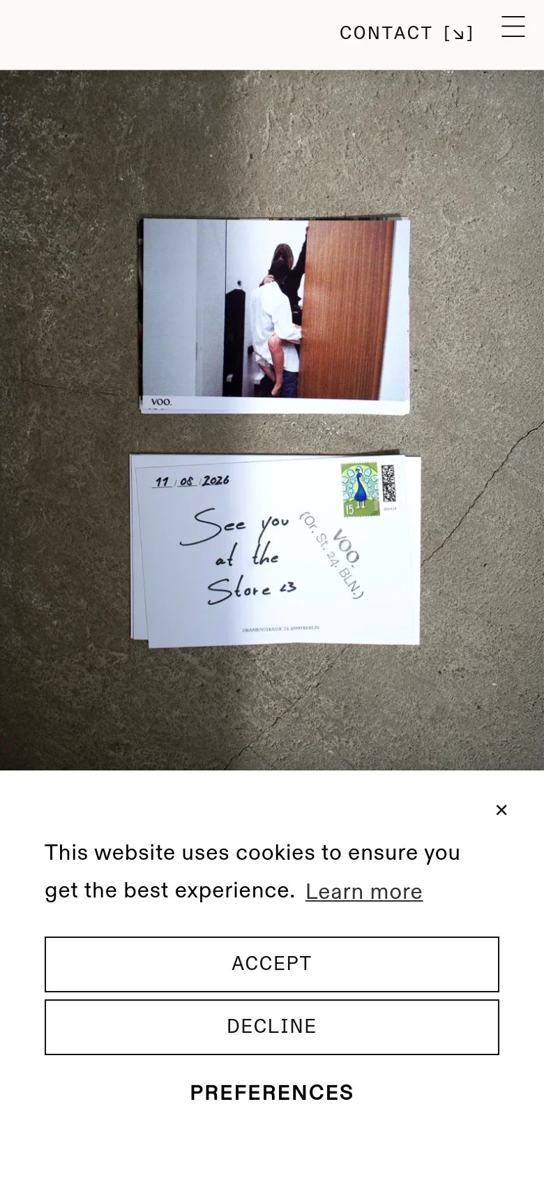 The mobile version uses a single-column vertical layout optimized for scrolling. The hero image of the photograph and note is centered, followed by a stacked series of full-width images and text blocks. A hamburger menu and 'CONTACT' link are located in the header, and a cookie consent banner appears at the bottom of the screen.