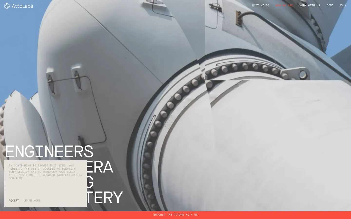 The desktop version features a large hero image of a metallic turbine structure against a blue sky. The headline 'ENGINEERS FOR NEW ERA EMBODYING REAL MASTERY' is overlaid in large white text on the left, with a navigation menu at the top right and a cookie consent banner at the bottom left. A bright orange call-to-action bar sits at the very bottom of the screen.