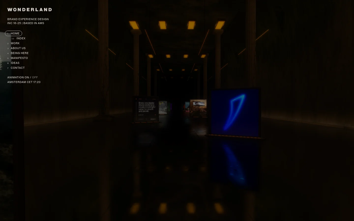 The desktop homepage features a dark, cinematic hero section showing a dimly lit hallway with glowing pillars and illuminated digital displays. The layout includes a minimalist navigation menu on the left with text links like 'HOME' and 'WORK', and the studio name 'WONDERLAND' in bold white typography at the top left.