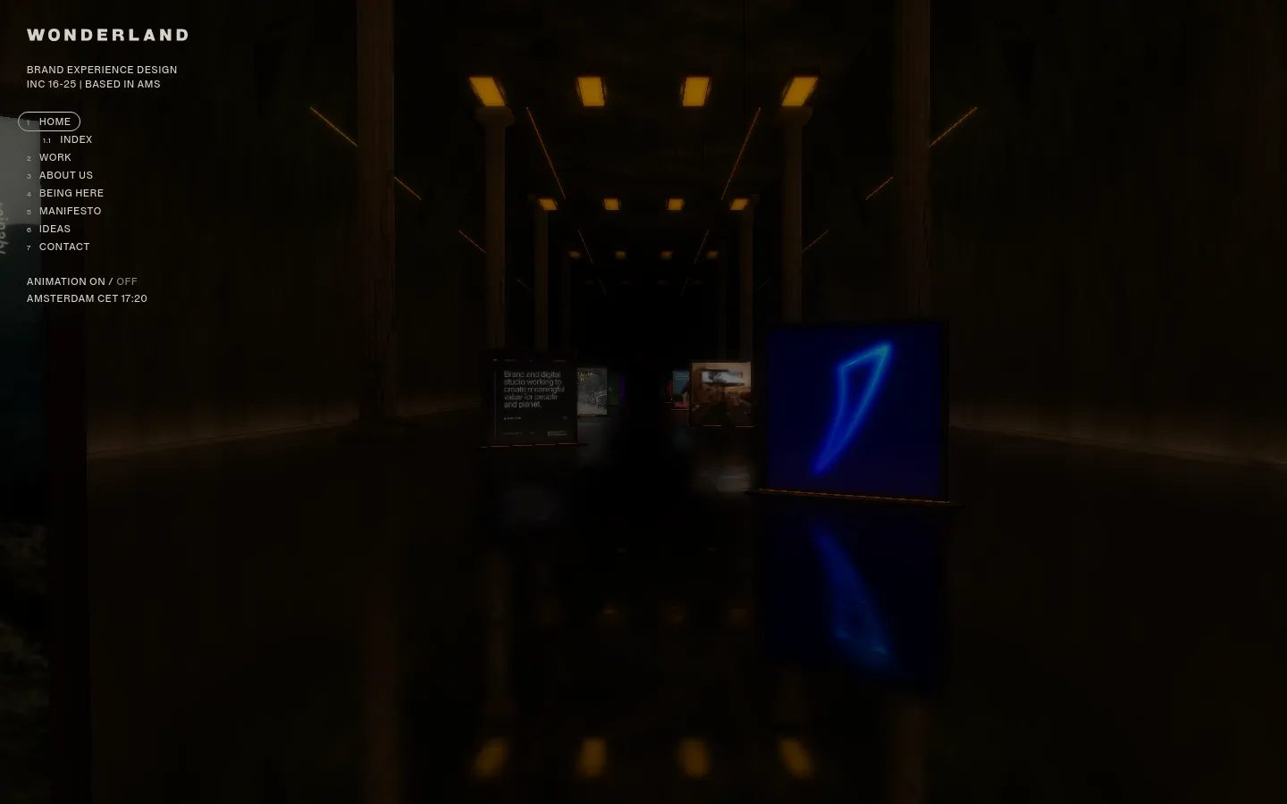 The desktop homepage features a dark, cinematic hero section showing a dimly lit hallway with glowing pillars and illuminated digital displays. The layout includes a minimalist navigation menu on the left with text links like 'HOME' and 'WORK', and the studio name 'WONDERLAND' in bold white typography at the top left.