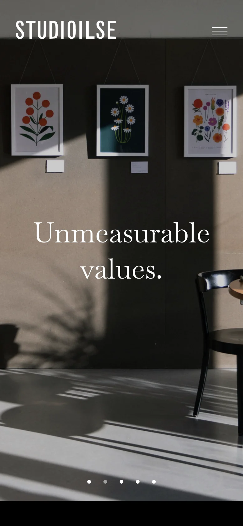 The mobile version maintains the minimalist aesthetic but transitions to a vertical stack. The hero image occupies the full viewport with the brand name 'STUDIOILSE' and a hamburger menu icon at the top, while the text overlay and pagination dots are centered over the large-scale imagery.