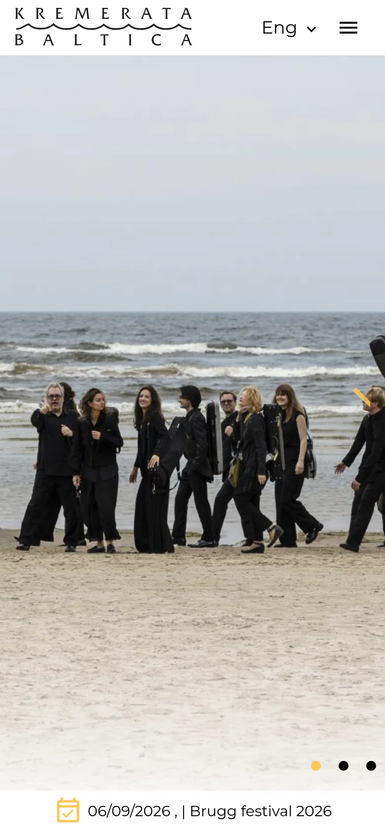 The mobile version presents a simplified layout with a large hero image of the orchestra on a beach. The navigation is condensed into a hamburger menu next to the logo and a language selector. An event date and title are pinned to a white bar at the bottom of the screen, and the hero image includes navigation dots and an arrow for the slider.