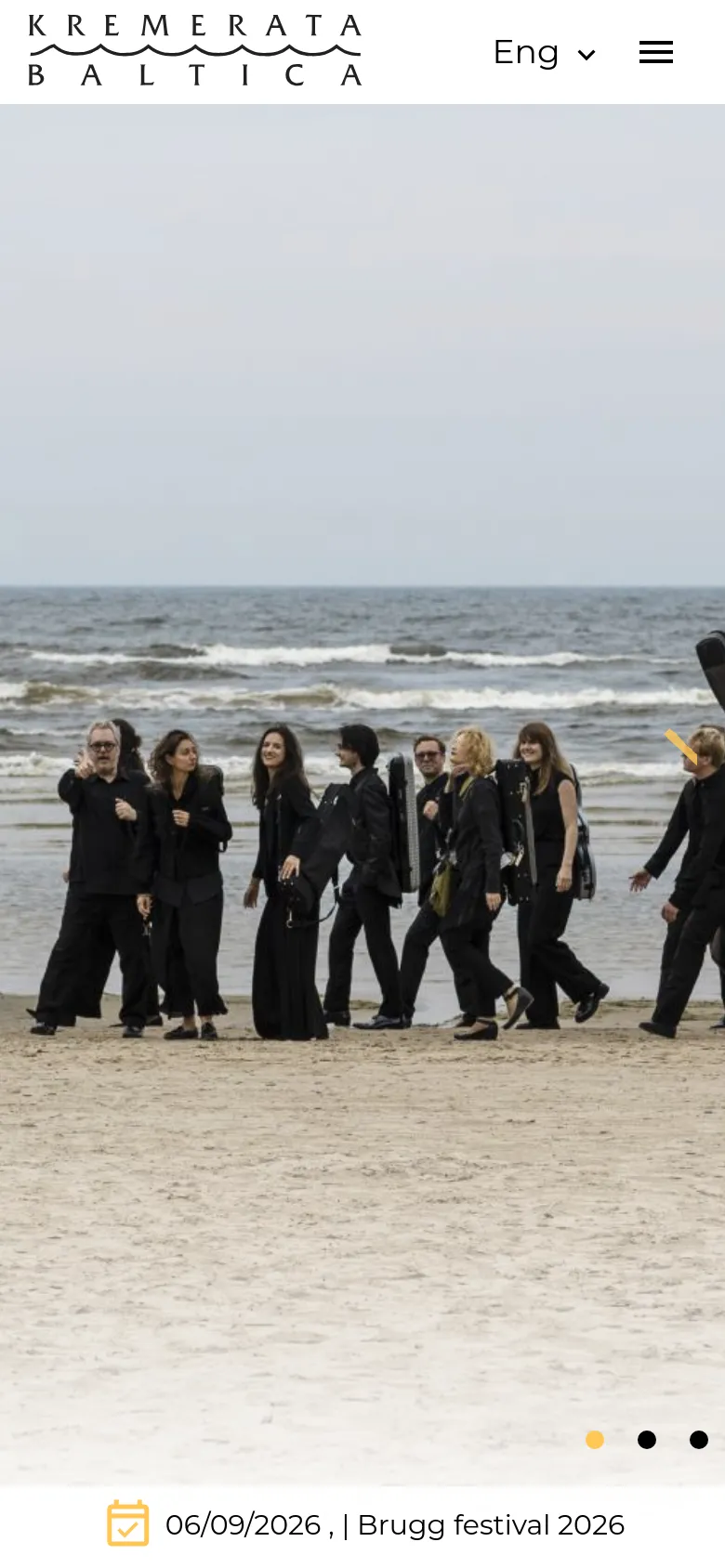 The mobile version presents a simplified layout with a large hero image of the orchestra on a beach. The navigation is condensed into a hamburger menu next to the logo and a language selector. An event date and title are pinned to a white bar at the bottom of the screen, and the hero image includes navigation dots and an arrow for the slider.