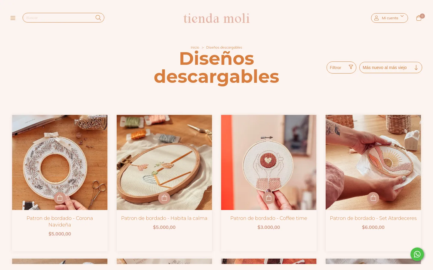 The desktop website features a light beige background with the title 'Diseños descargables' in large, brown serif font. Below the header, a grid of embroidery pattern product cards displays high-quality photos of embroidery hoops, product titles, and prices. A filter button and a sorting dropdown menu are positioned above the product grid.