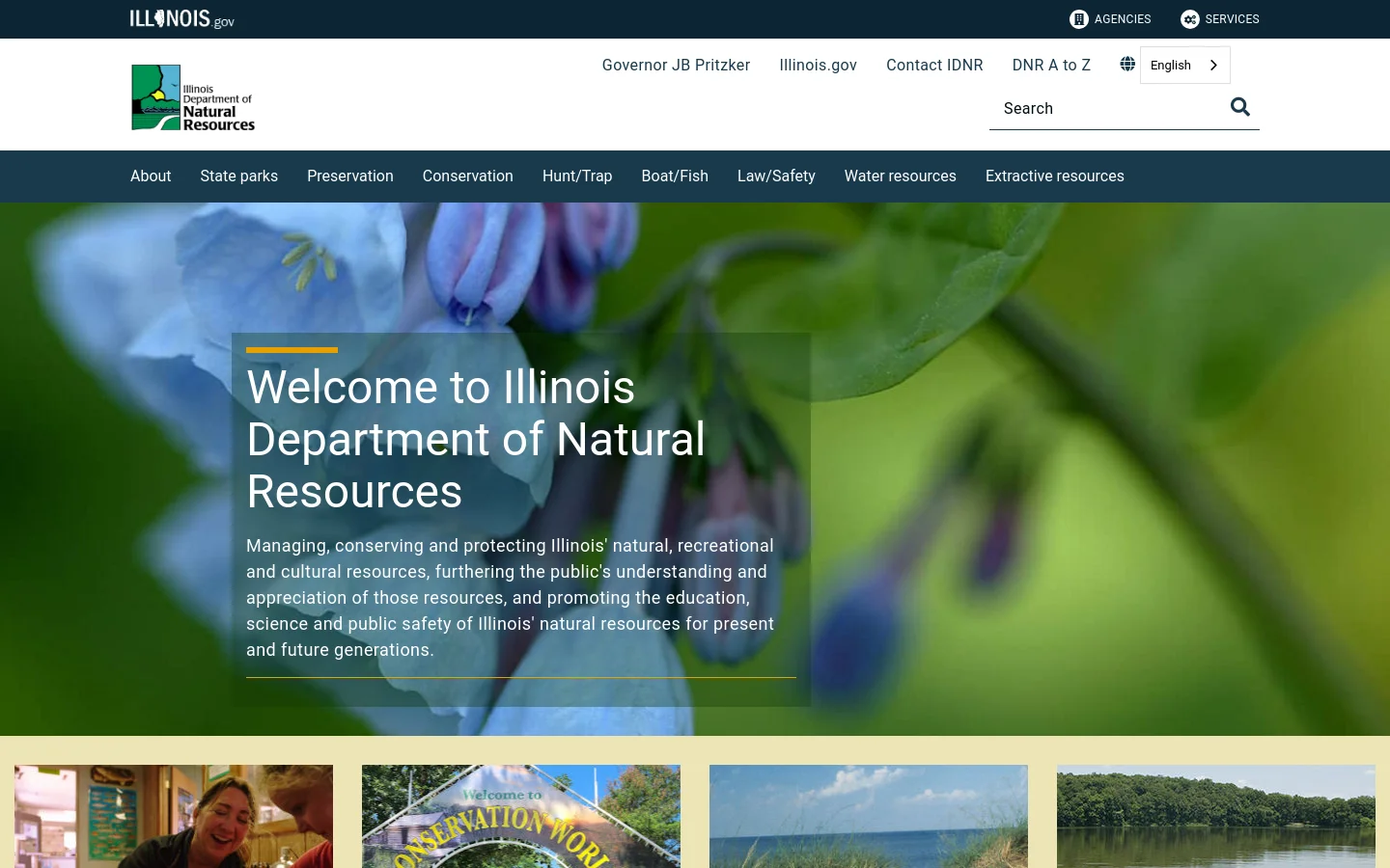 The Illinois Department of Natural Resources homepage features a large hero image of a blue flower with a dark overlay containing the welcome headline and mission statement. A white header includes the agency logo, navigation links for Governor JB Pritzker and Illinois.gov, a search bar, and a dark blue primary navigation menu with categories like State Parks and Conservation. The layout is wide and organized with a clean, professional aesthetic.