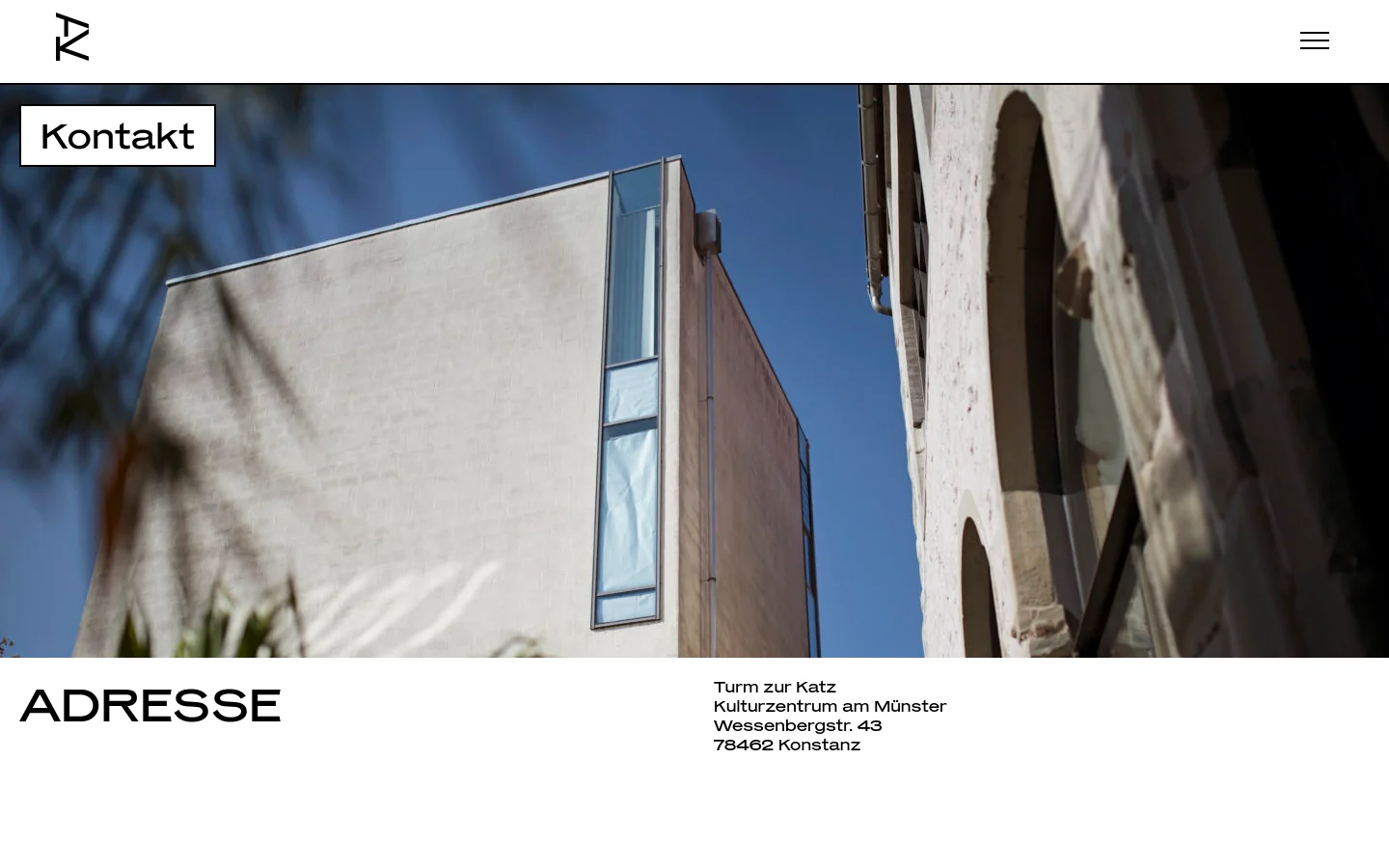 The desktop contact page features a large hero image of a modern stone building against a blue sky, with the headline 'Kontakt' in a white box. Below, the 'ADRESSE' section displays the center's address in a clean, minimalist layout with black text on a white background.