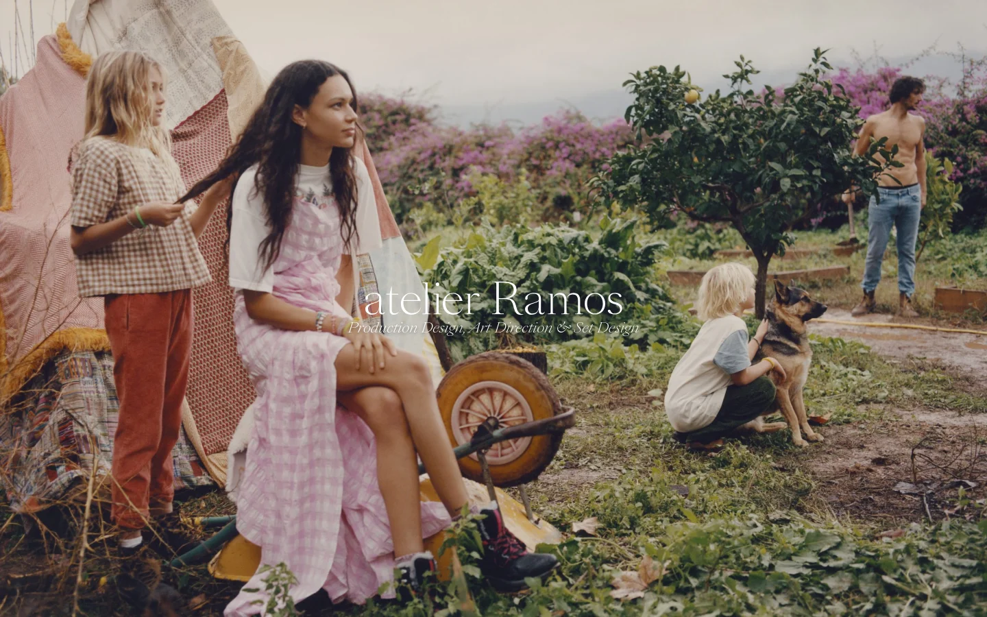 The desktop homepage features a large, full-width hero image of people in a garden setting with the text 'atelier Ramos' and 'Production Design, Art Direction & Set Design' overlaid in white. Below the hero, a grid of project thumbnails displays various fashion and interior design works with category labels and credits. The layout is clean with a minimalist aesthetic and neutral tones.