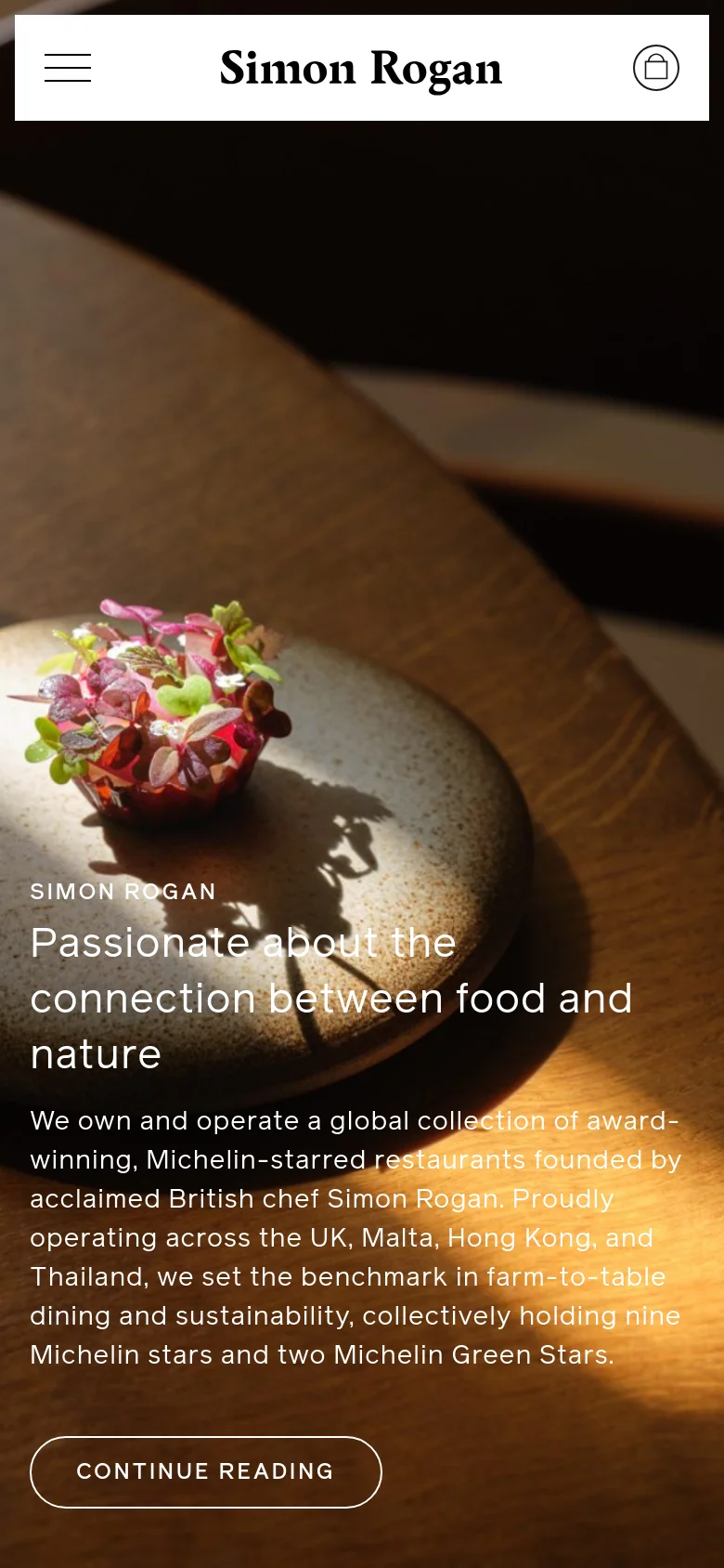 The mobile version simplifies the layout, displaying only the Simon Rogan logo, a hamburger menu icon, and a shopping bag icon at the top. The hero image and text content, including the headline and 'Continue Reading' button, are scaled to fit the vertical screen, maintaining the same warm, earthy color palette.