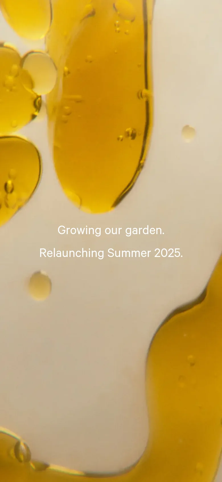 The mobile version maintains the same aesthetic, featuring the golden oil droplet imagery and white headline text. The layout is vertically oriented to fit the narrow screen, with the text centered over the macro photography of the liquid.
