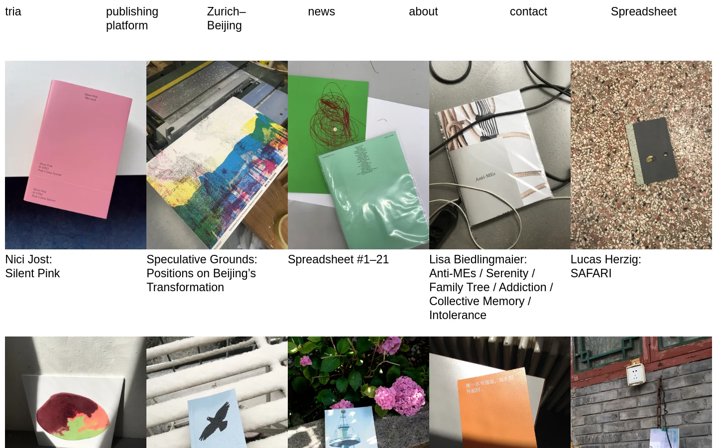 The desktop homepage for tria publishing platform features a minimalist design with a white background and a grid of large, colorful photographs of various art publications. A navigation menu at the top includes links for news, about, contact, and spreadsheet, alongside the brand name and location. The layout uses a clean, spacious aesthetic to showcase different book projects like 'Silent Pink' and 'SAFARI'.