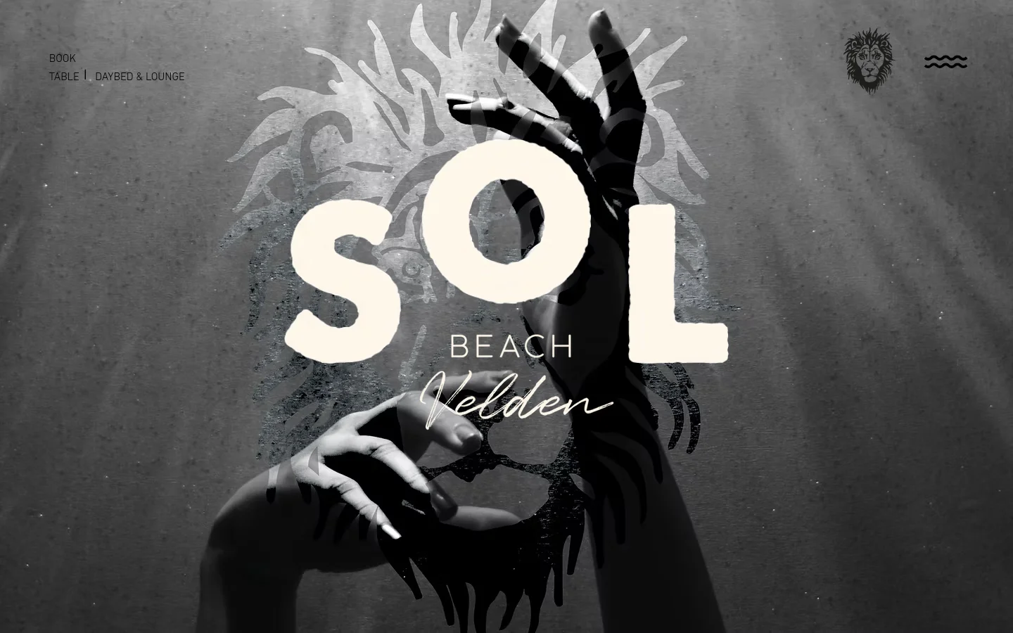 The desktop homepage features a large, black and white hero image of hands framing the text 'SOL BEACH Velden' against a textured background with a lion graphic. The navigation includes 'BOOK TABLE | DAYBED & LOUNGE' in the top left and a lion logo in the top right. A light-colored section below contains text regarding a winter break and reopening in May 2026.