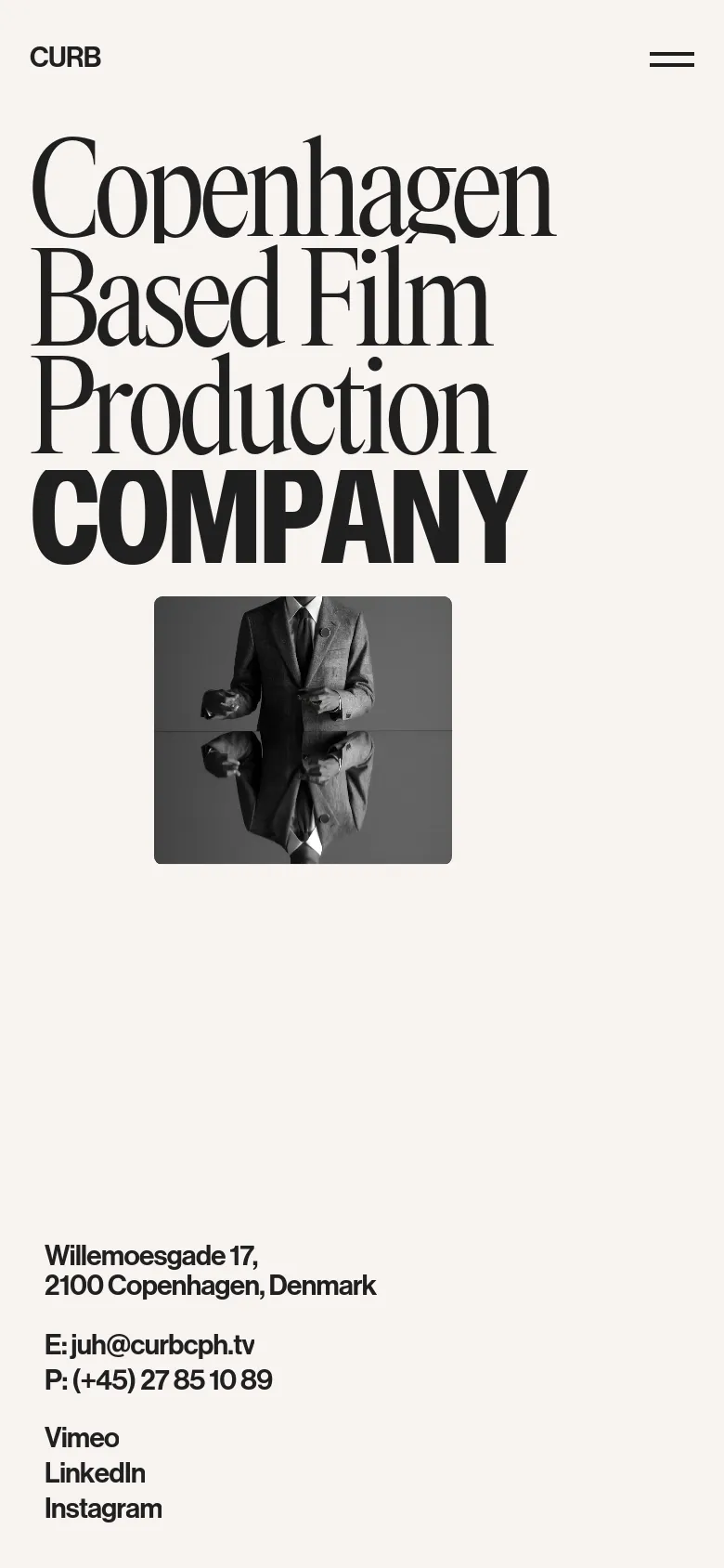 The mobile version presents a vertically stacked layout with the same large black headline and a black-and-white artistic image of a man in a suit. The contact information and social media links are moved to the bottom of the screen for easy scrolling on a narrow display.