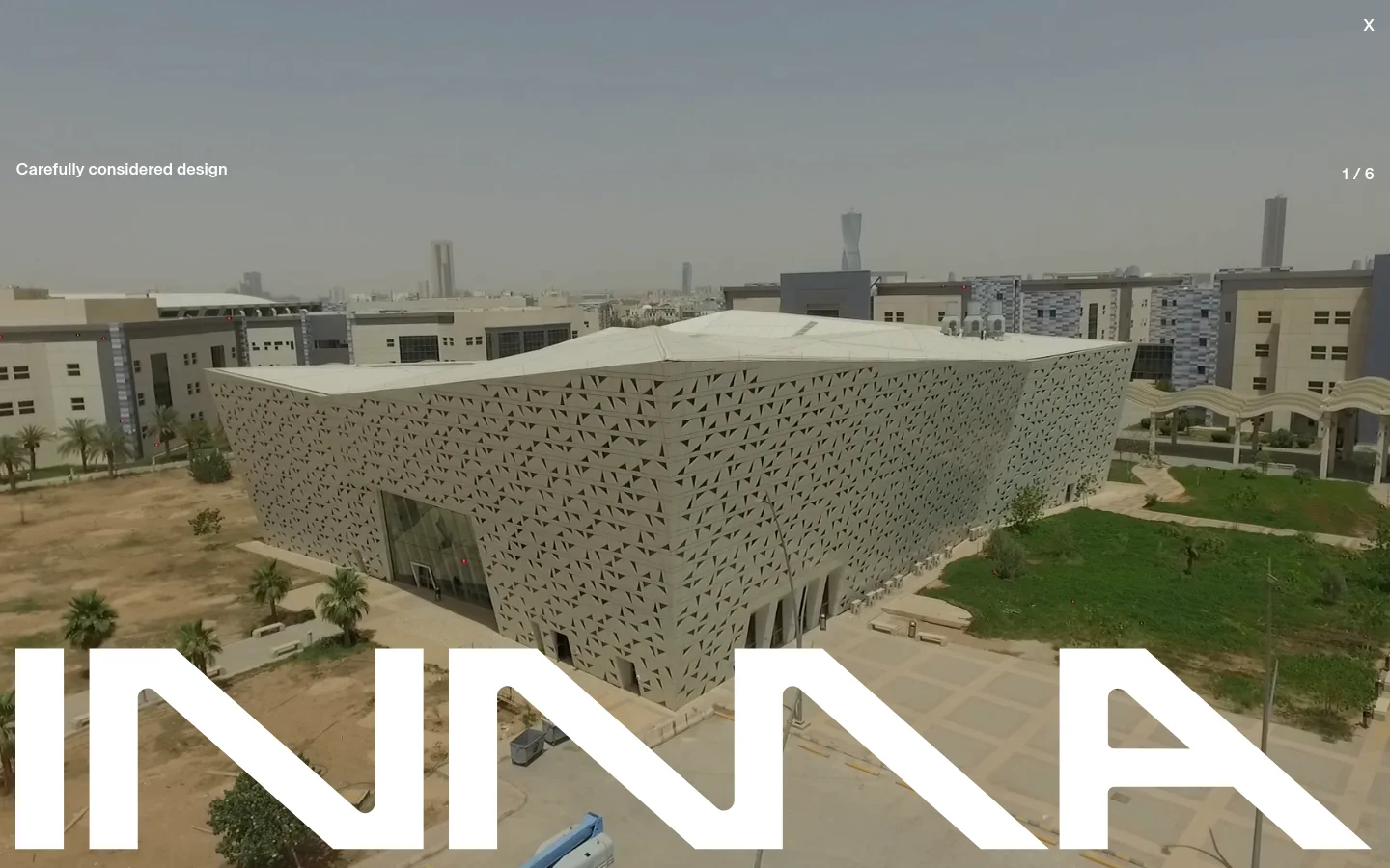 The INMA homepage features a large hero image of a modern building with a geometric patterned facade. A navigation menu sits at the top with links to About, Projects, Expertise, Technologies, Partners, and Info. Below the hero section, a text block introduces the company's focus on bespoke building envelopes, followed by a carousel of project highlights.