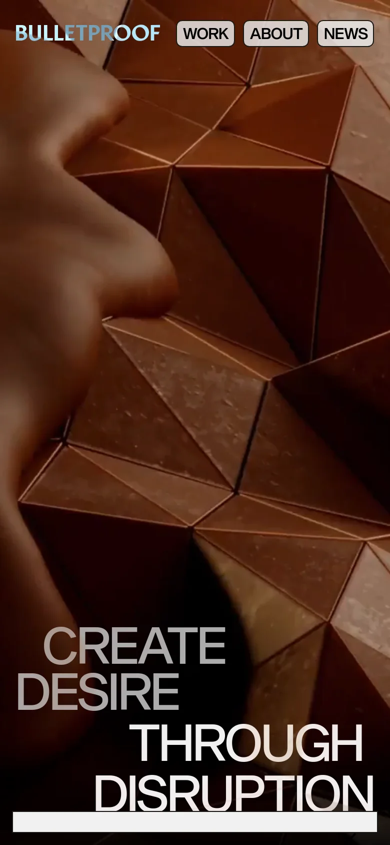 The mobile version presents a simplified layout with the 'BULLETPROOF' logo and navigation buttons stacked or condensed at the top. A large hero image with a copper-toned geometric texture and a human silhouette is visible behind the text. The main headline 'CREATE DESIRE THROUGH DISRUPTION' is prominently displayed in large white sans-serif type at the bottom.