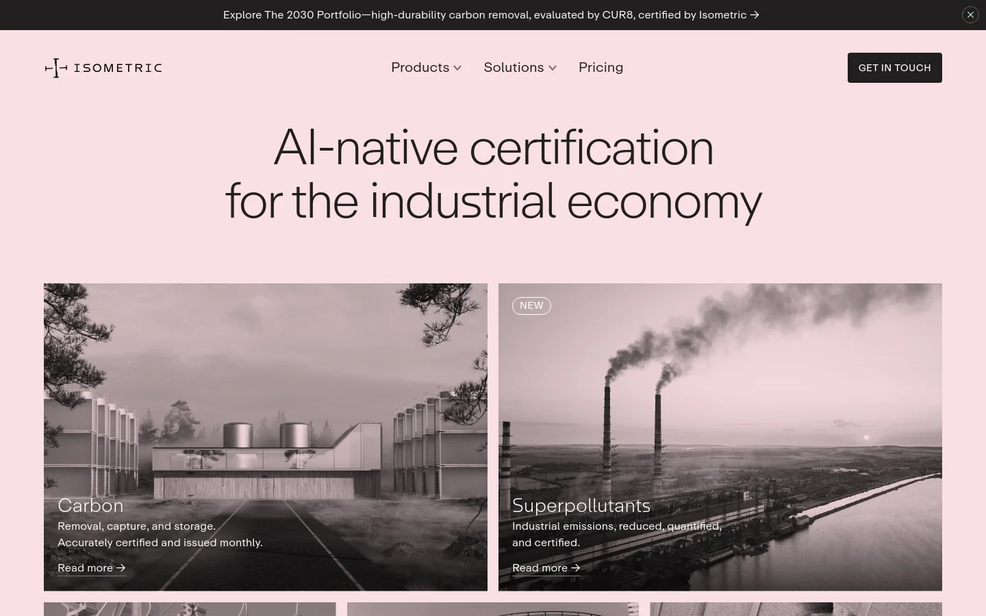 The desktop homepage features a minimalist design with a light pink background and large, centered black text reading 'AI-native certification for the industrial economy.' Below the headline, two large side-by-side photographic tiles show industrial landscapes in grayscale; the left tile is for 'Carbon' and the right for 'Superpollutants,' both including 'Read more' links. A top navigation bar includes the Isometric logo, dropdown menus for Products and Solutions, Pricing, and a 'Get In Touch' button.
