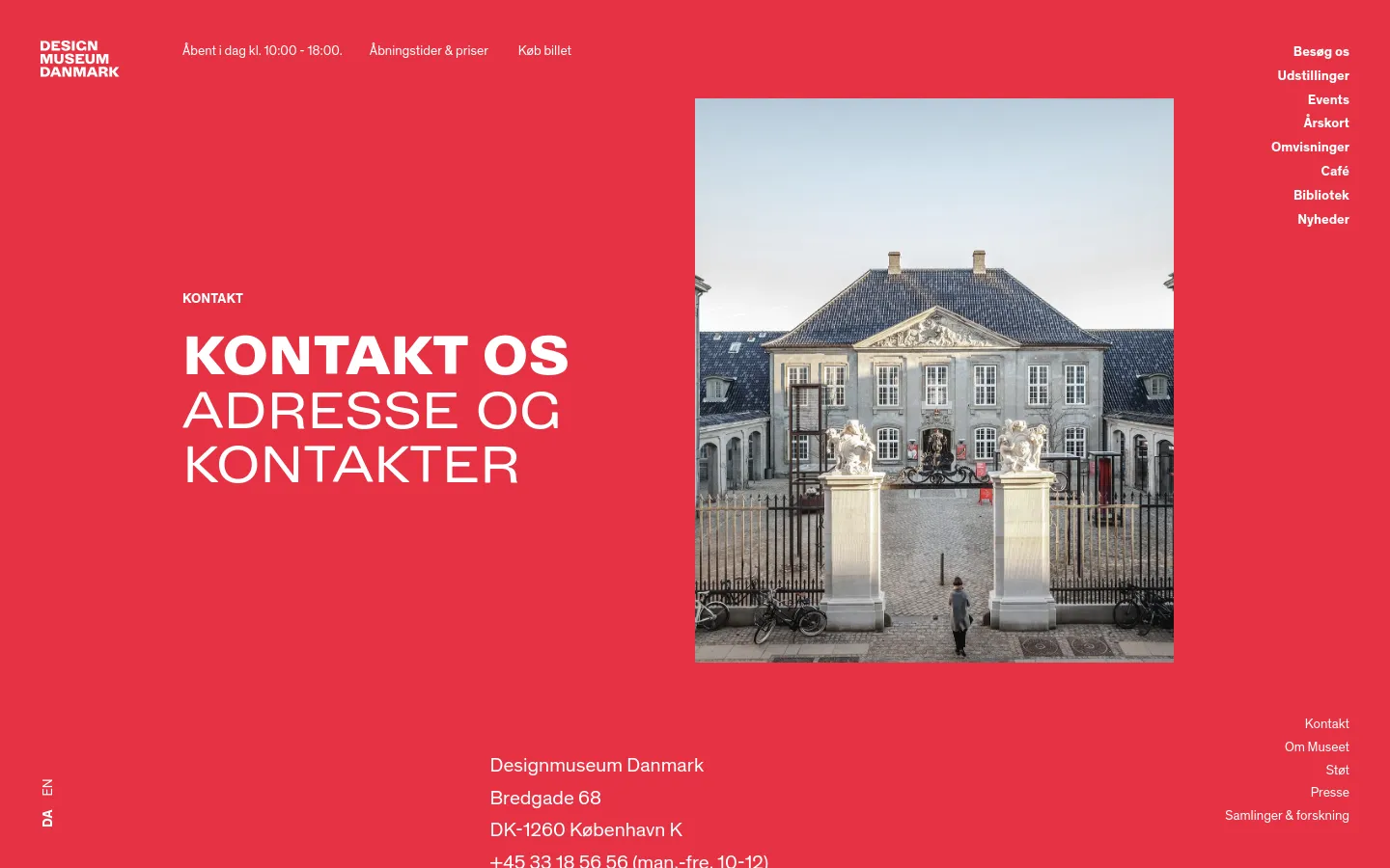 The desktop page features a bold red background with white text. A large headline reads 'KONTAKT OS ADRESSE OG KONTAKTER' next to a large rectangular photograph of the Designmuseum Danmark building entrance with white statues and a black iron gate. Navigation links are spread across the top and bottom edges of the screen.