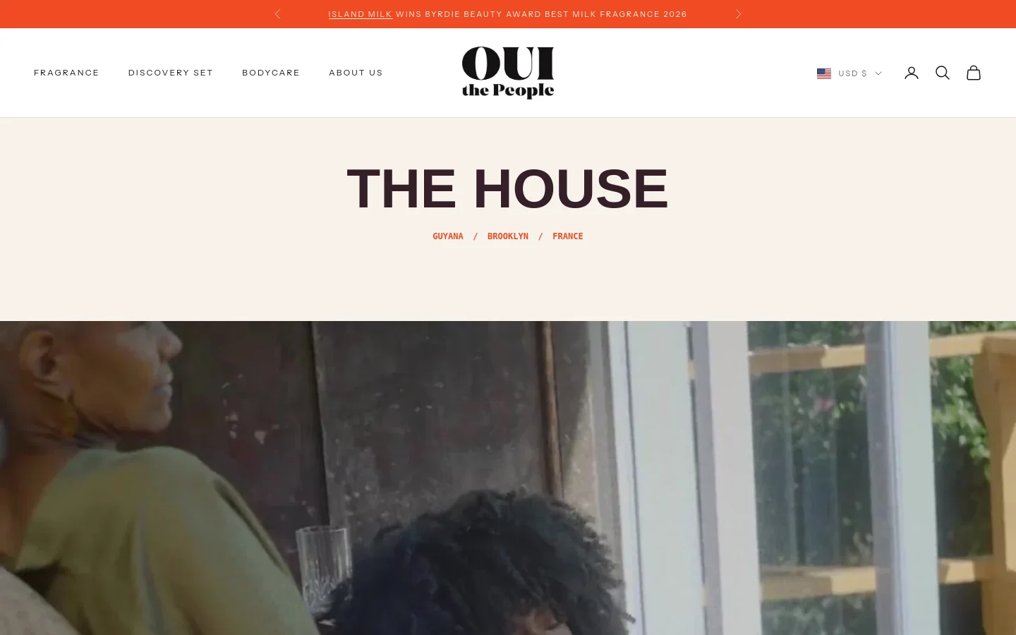 The desktop About Us page features a minimalist white header with navigation links and a central logo. The hero section displays the large headline 'THE HOUSE' over a wide lifestyle image, followed by a navigation menu for Guyana, Brooklyn, and France. An orange announcement bar sits at the top of the page.