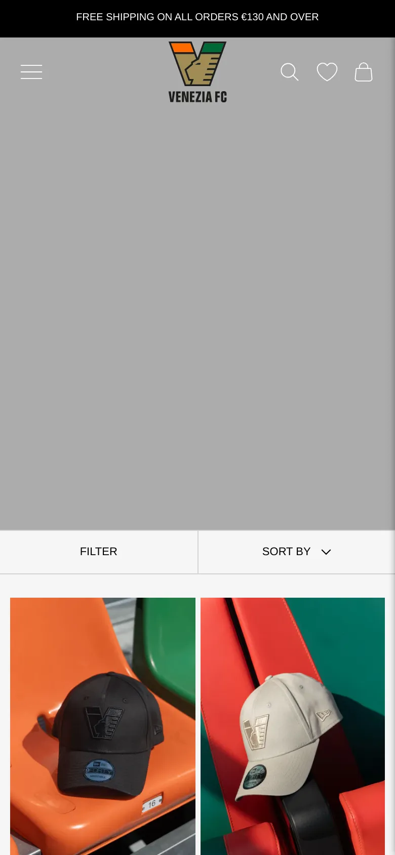 The mobile version presents a simplified layout with a large hero image and a sticky header containing a hamburger menu, the Venezia FC logo, search, favorites, and cart icons. The product grid is condensed into a single or double column view, and the 'Filter' and 'Sort By' options are presented as large, full-width buttons for easier touch interaction.
