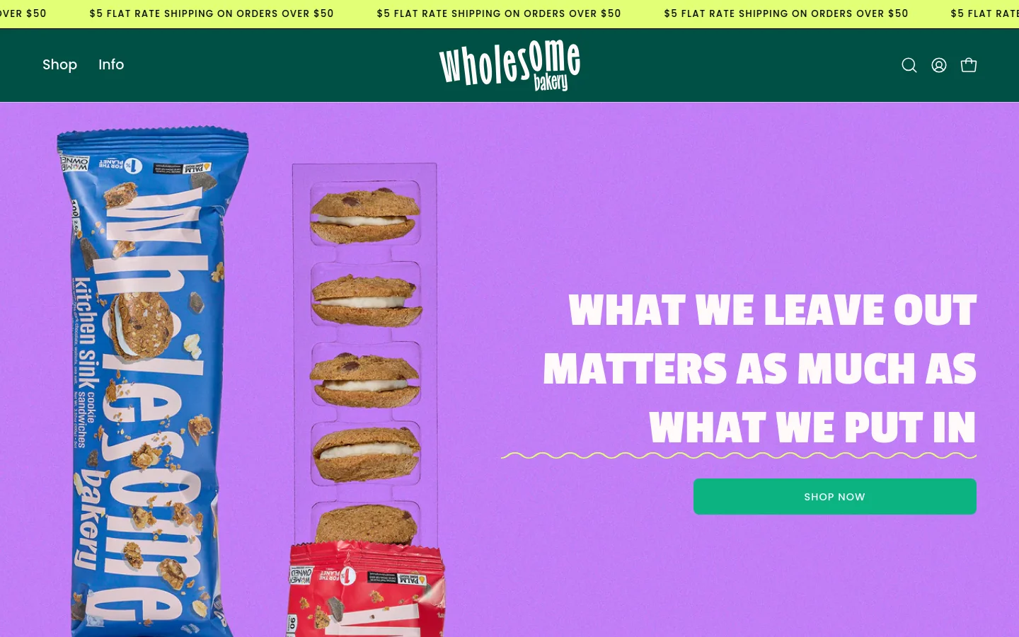 Desktop homepage featuring a vibrant purple hero section with images of cookie sandwich packaging on the left. A large headline reads 'WHAT WE LEAVE OUT MATTERS AS MUCH AS WHAT WE PUT IN' next to a green 'SHOP NOW' button. A dark green navigation bar at the top includes the Wholesome Bakery logo, shop links, and a search icon.