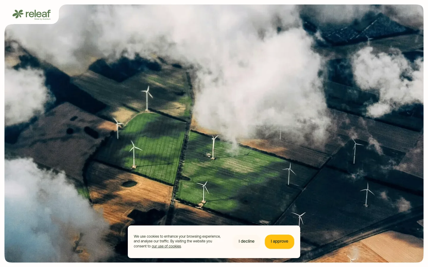 The desktop landing page features a large aerial hero image of green farmland with wind turbines partially obscured by white clouds. A large white headline reads 'Releaf® is plant-based, recyclable, and designed for circularity' over the center, and a cookie consent banner appears at the bottom.