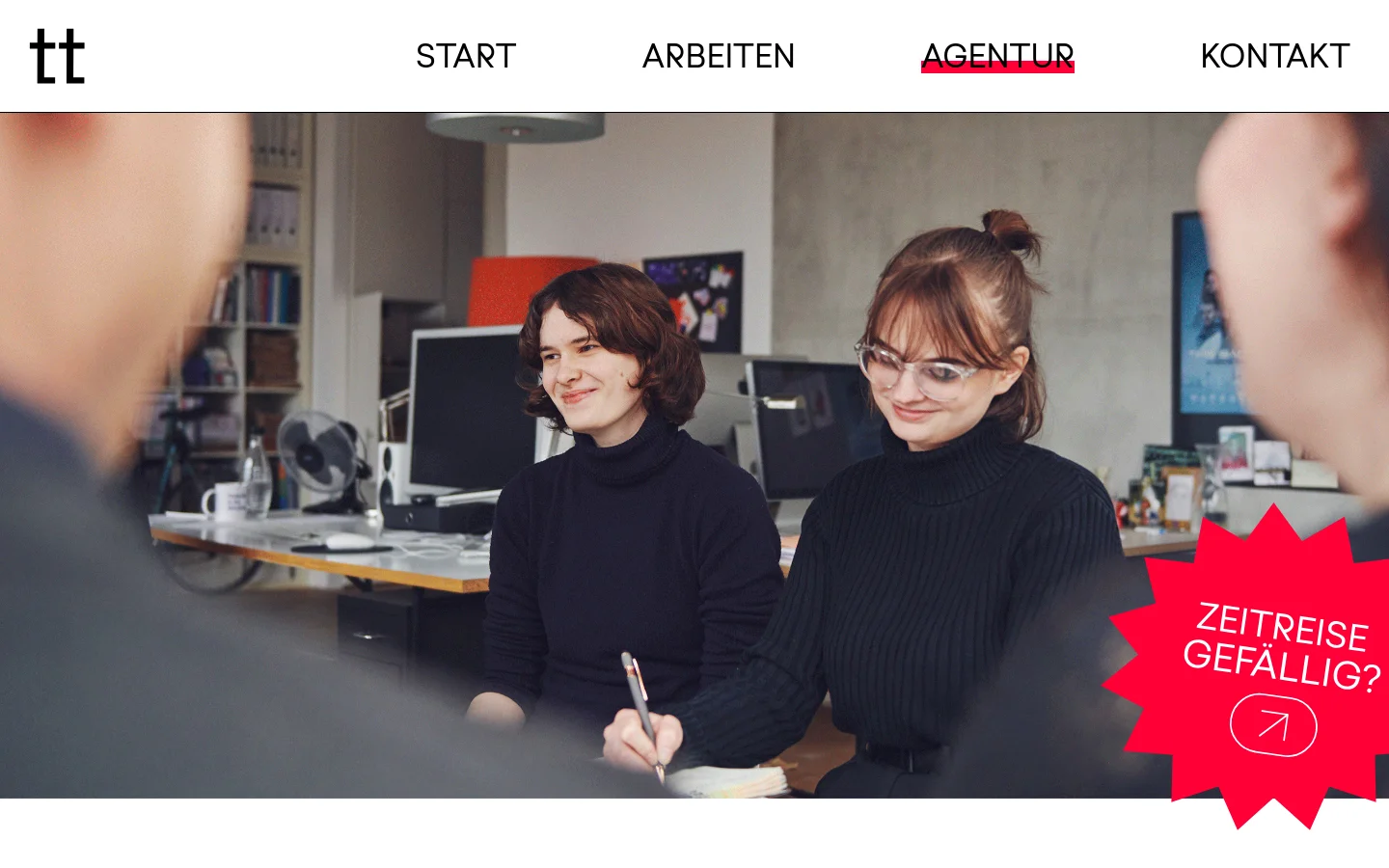 The desktop page features a clean white header with the 'tt' logo and navigation links for Start, Arbeiten, Agentur, and Kontakt. A large hero image shows a team of designers working in a bright office, overlaid with a bright red starburst graphic containing the text 'ZEITREISE GEFÄLLIG?' and an arrow icon. Below, the 'Wer wir sind' section introduces the agency's philosophy with text and portraits of the founders, Stefan Semrau and Christian Hruschka.
