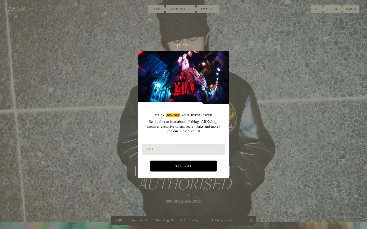 The desktop homepage features a dark, cinematic aesthetic with a large central pop-up offering a 10% discount. Behind the pop-up, a model in streetwear is visible against a textured grey background, with navigation links for Shop, Collections, and Explore at the top. The layout is centered and minimalist, using high-contrast white text on dark imagery.