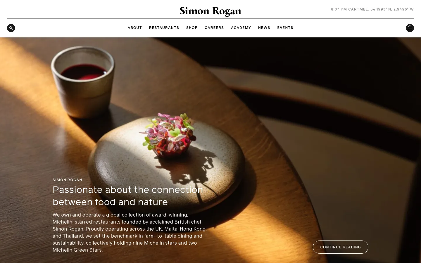 The desktop homepage features a large, warm-toned hero image of a small dish on a wooden table with the headline 'Passionate about the connection between food and nature.' A navigation bar at the top includes the Simon Rogan logo, links for About, Restaurants, Shop, Careers, Academy, News, and Events, alongside a search icon and a shopping bag icon. The layout is clean with white text overlaid on the dark, moody photography.