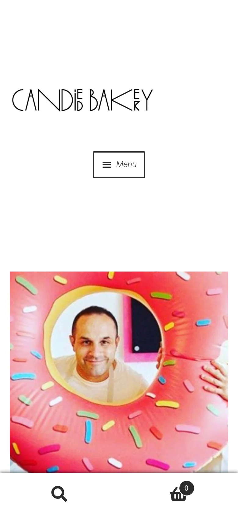 The mobile version presents a simplified vertical layout with the Candied Bakery logo at the top and a centered 'Menu' button. The hero image of the man and woman with the pink donut inflatable spans the width of the screen, followed by a single-column product display below.
