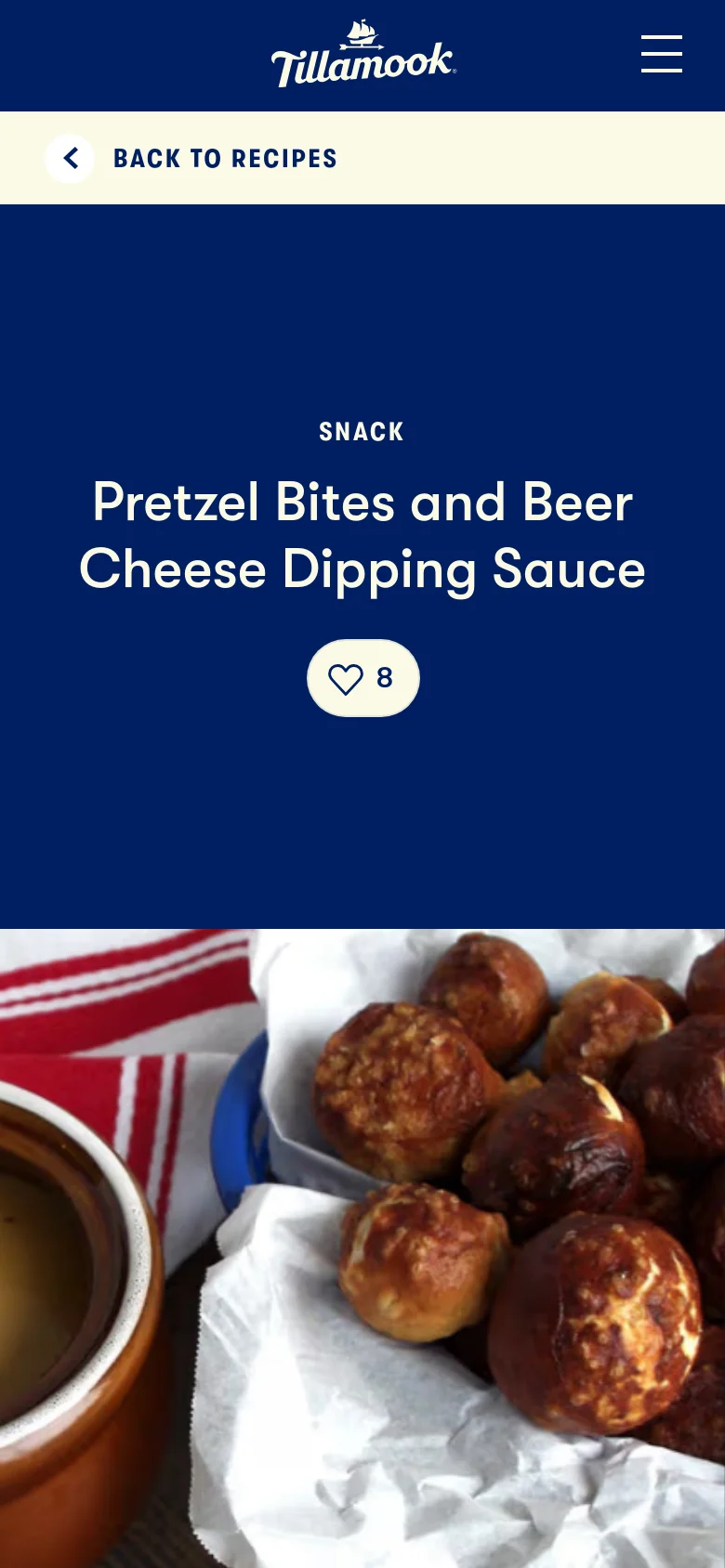 The mobile version presents a stacked layout where the dark blue hero section with the recipe title and heart icon appears above the food photograph of pretzel bites. The top navigation is condensed into a hamburger menu icon next to the Tillamook logo, and a 'Back to Recipes' button is prominently displayed below the header.