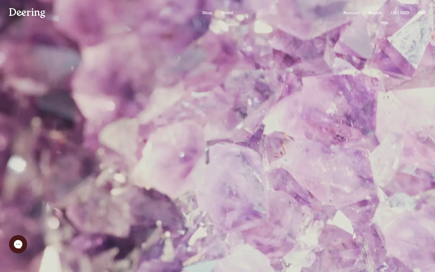The desktop page features a large hero image of purple amethyst crystals with the Deering logo and navigation links like Shop, World, Account, and Search at the top. Below the hero image, the Client Relations content is organized into two columns with contact information on the left and a FAQ section on the right. The layout is clean with a white background and dark text.