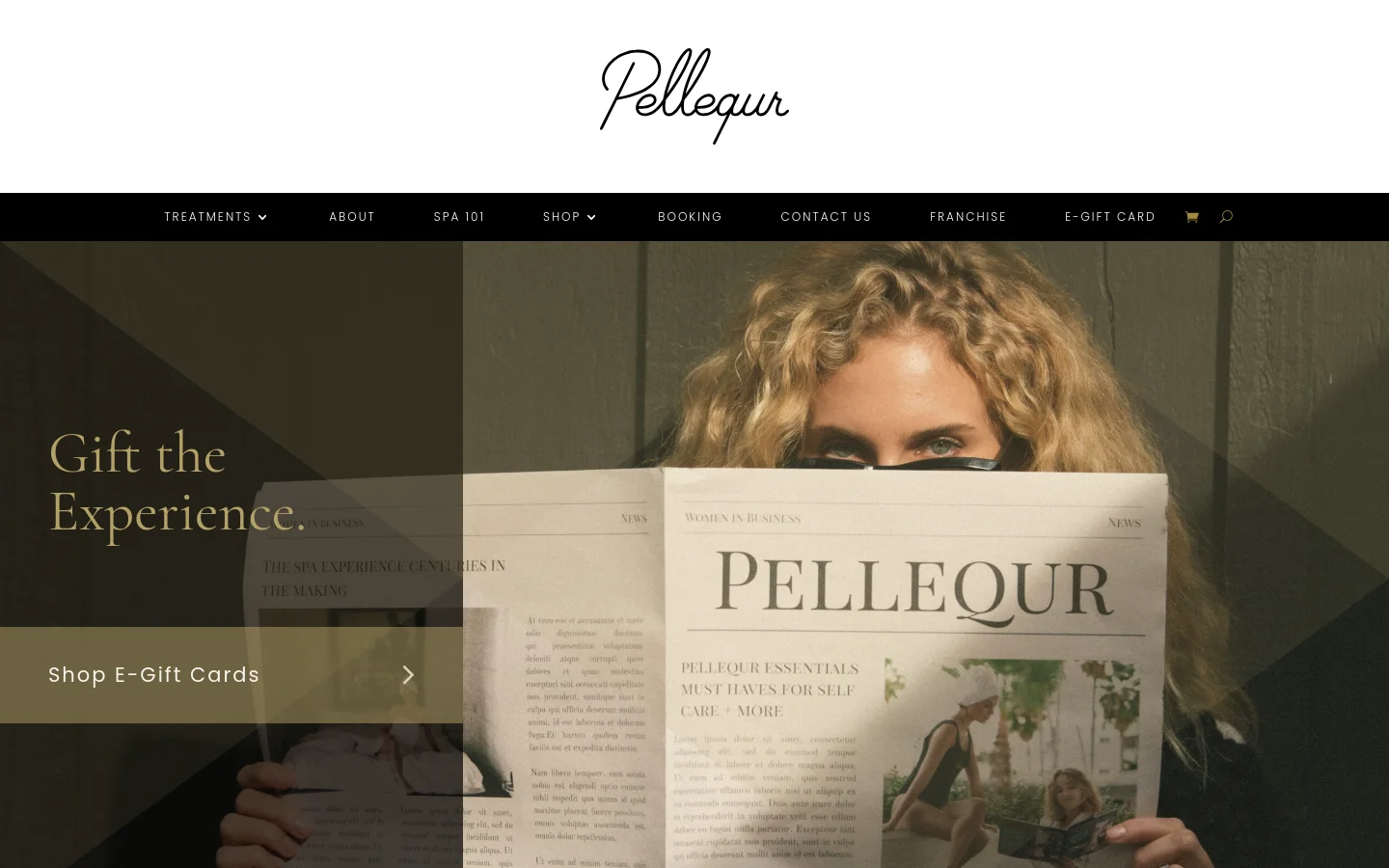 The Pellequr homepage features a large hero image of a woman holding a newspaper with the brand name on it, overlaid with the text 'Gift the Experience.' and a 'Shop E-Gift Cards' call to action. A black navigation bar at the top includes links for Treatments, About, Spa 101, Shop, Booking, Contact Us, Franchise, and E-Gift Card, alongside a shopping cart and search icon. The design uses a sophisticated palette of black, white, and muted gold tones.