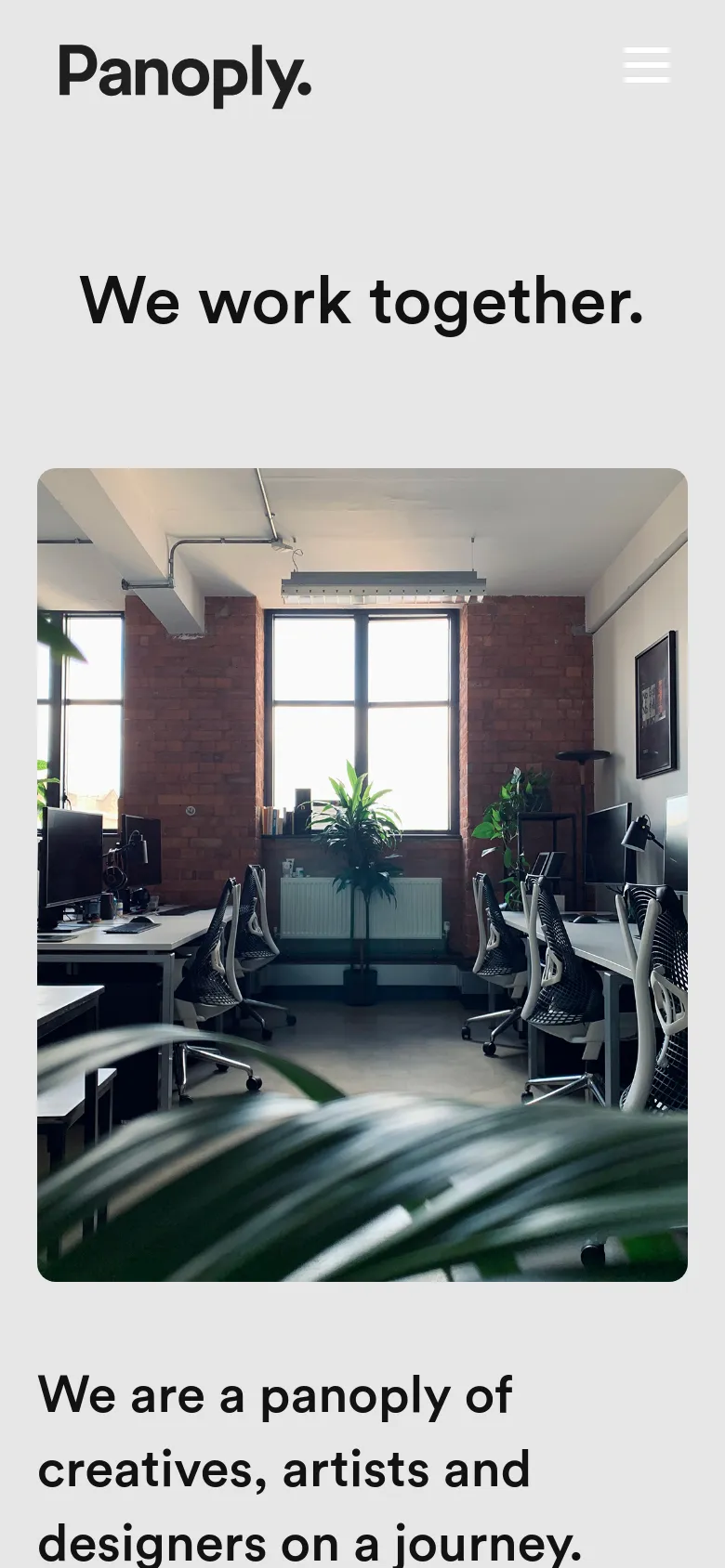 The mobile version uses a similar light gray color scheme but features a condensed layout with a hamburger menu icon next to the Panoply logo. The headline 'We work together' is centered above a large, vertically oriented studio office photograph. The text and contact details are stacked vertically to fit the narrow screen width.