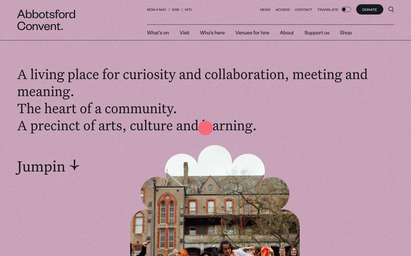 The Abbotsford Convent homepage features a light purple background with large serif typography stating, 'A living place for curiosity and collaboration, meeting and meaning.' Below the text, a 'Jumpin' link with a downward arrow sits above a scalloped-edge photo of people dancing in front of a historic brick building. The desktop header includes navigation links like 'What's on' and 'Visit,' a 'Donate' button, and a search icon.