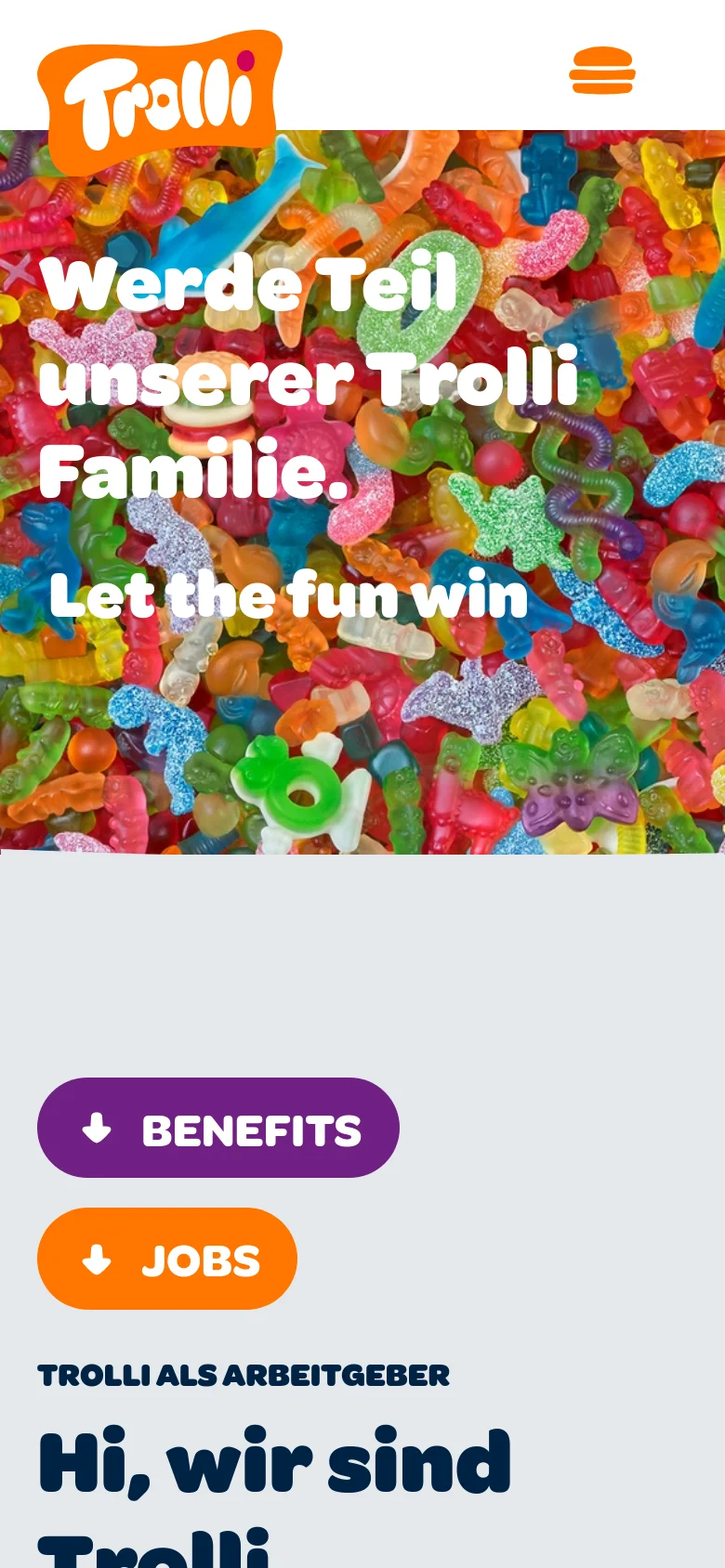 The mobile version simplifies the layout with a hamburger menu icon in the header next to the Trolli logo. The hero section remains a vibrant gummy candy collage with large white text overlays. The 'BENEFITS' and 'JOBS' buttons are stacked vertically on a light gray background above the main text content.