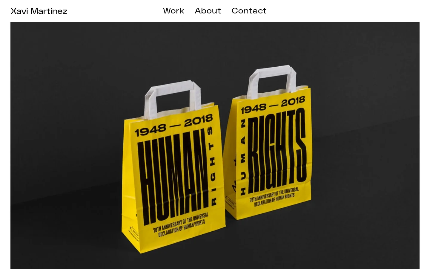 The desktop portfolio page features a minimalist design with a dark gray background and white text. A large hero image showcases two yellow shopping bags with bold black typography reading 'HUMAN RIGHTS 1948-2018' against a dark backdrop. Below the hero section, a grid of project thumbnails with titles like Sui, Slush, and Enerpoly is displayed.