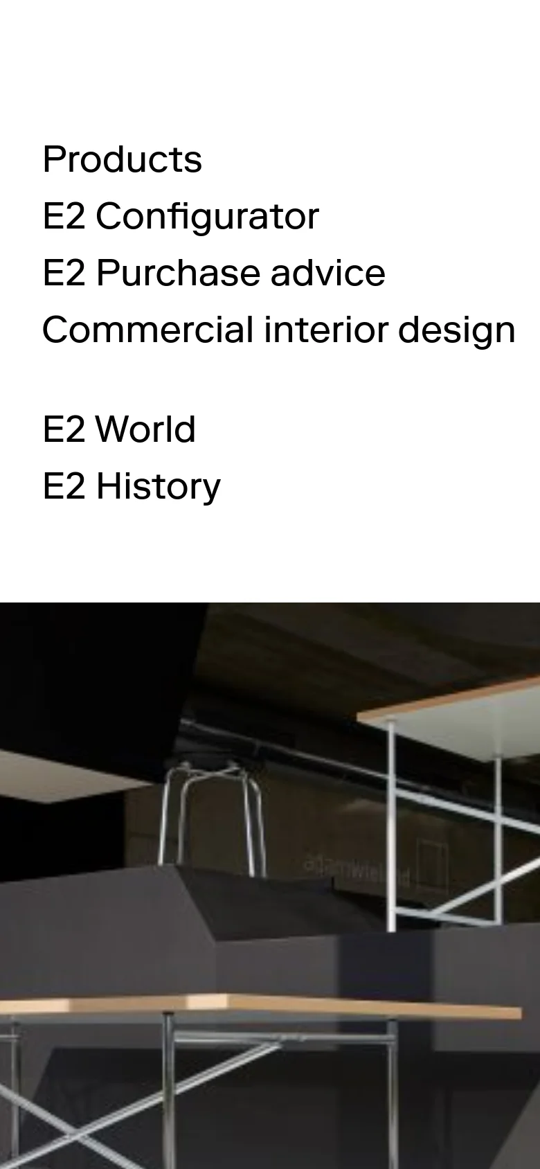 The mobile version presents a simplified vertical layout with navigation links stacked in a single column at the top. The hero image follows below, showing a close-up view of the E2 table structure in a contemporary showroom setting.