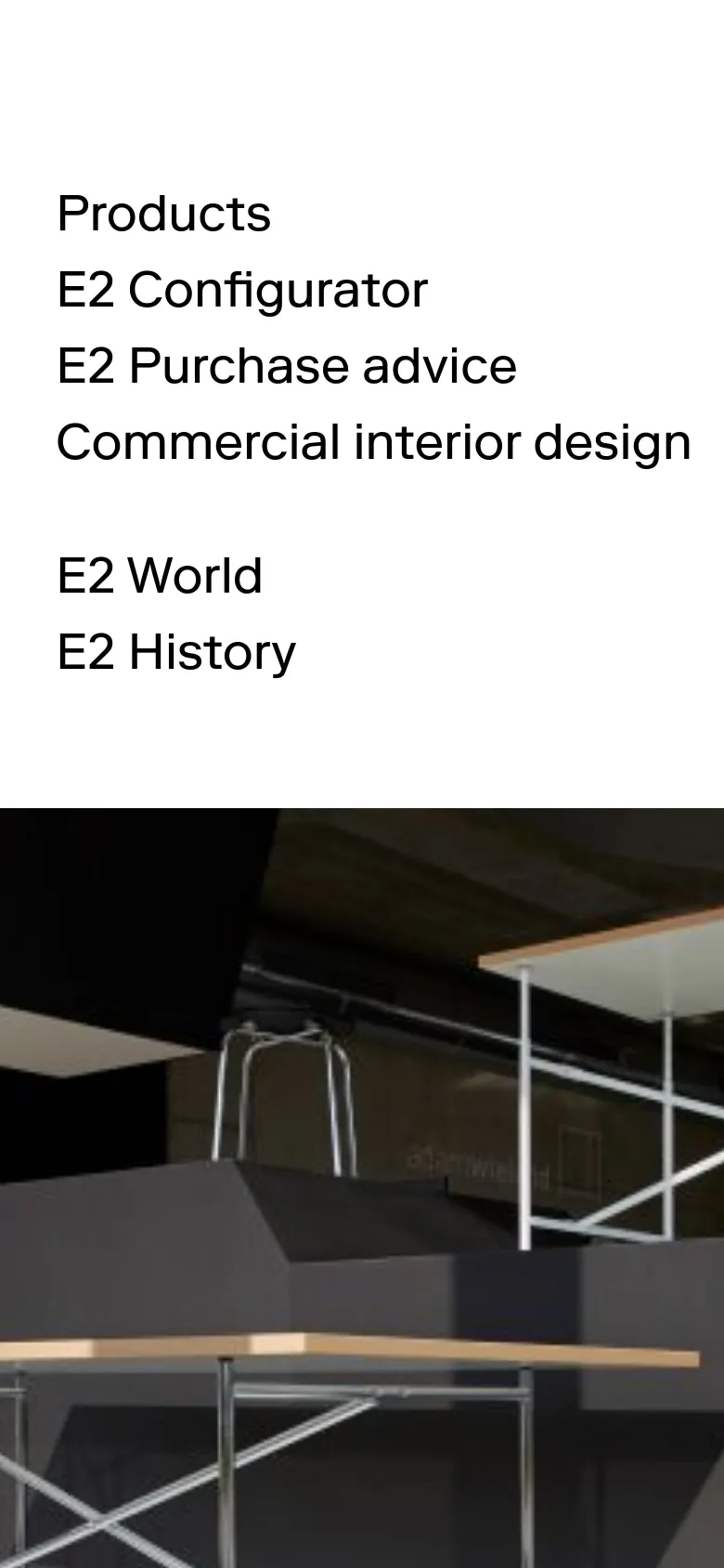 The mobile version presents a simplified vertical layout with navigation links stacked in a single column at the top. The hero image follows below, showing a close-up view of the E2 table structure in a contemporary showroom setting.