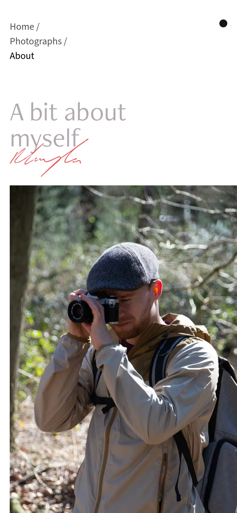 The mobile version maintains the minimalist aesthetic but stacks the content vertically, showing the navigation links and headline at the top. The hero image of the photographer is positioned below the text, filling the width of the screen. The overall color palette remains white and neutral with red accent text.