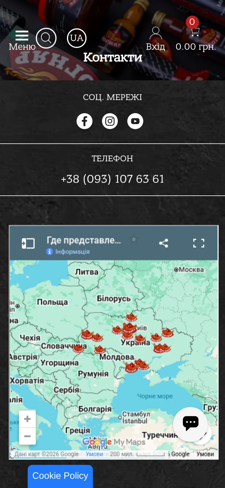The mobile version presents a simplified vertical layout with a dark background and a prominent 'Контакти' heading. A condensed Google Map is displayed, followed by social media links and the contact phone number. Navigation is handled via a bottom menu bar with icons for Menu, Search, Language, Login, and a Shopping Cart.