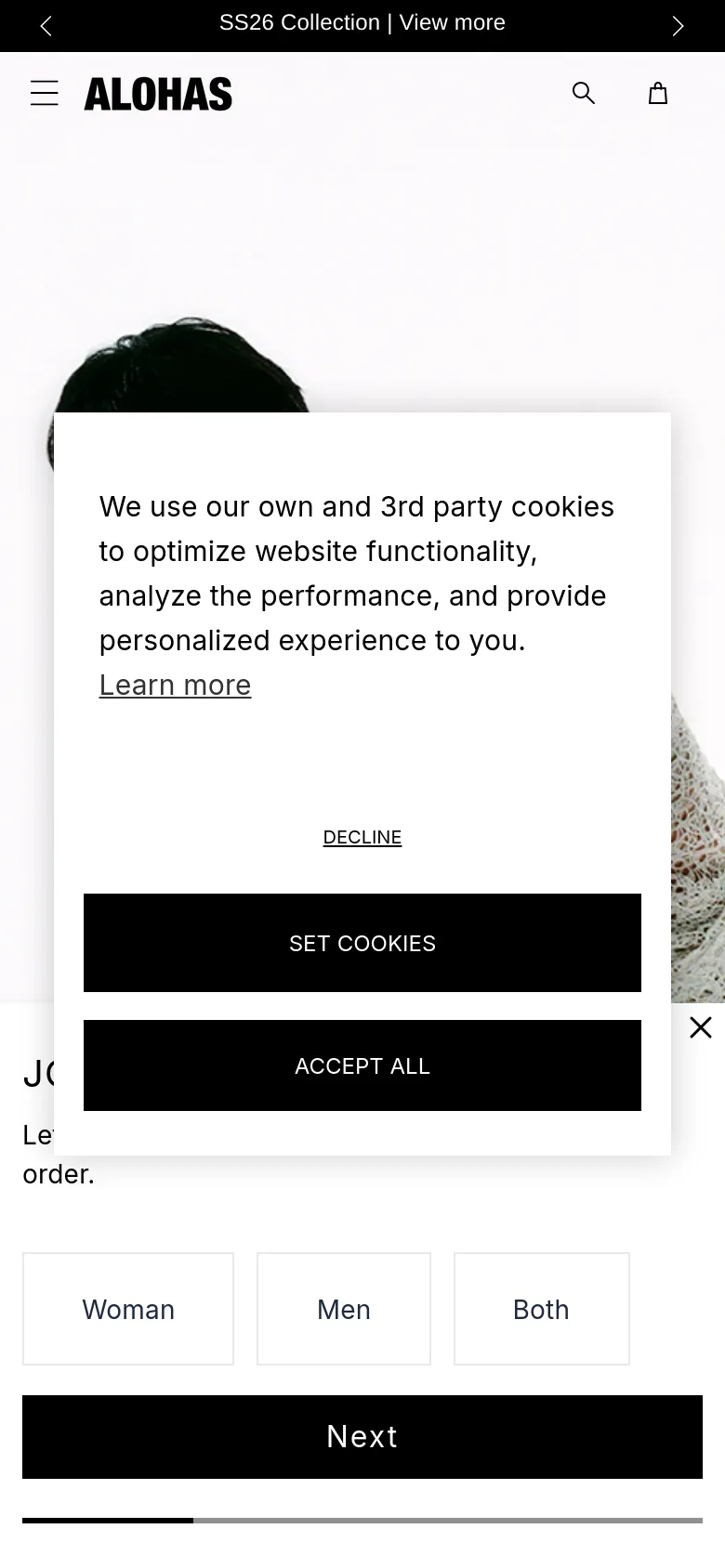 The mobile version displays a vertically oriented hero image with the same minimalist aesthetic and white color palette. The cookie consent pop-up is larger, covering much of the central view, and includes 'DECLINE', 'SET COOKIES', and 'ACCEPT ALL' buttons. The header is simplified with a hamburger menu, the ALOHAS logo, a search icon, and a shopping bag icon.