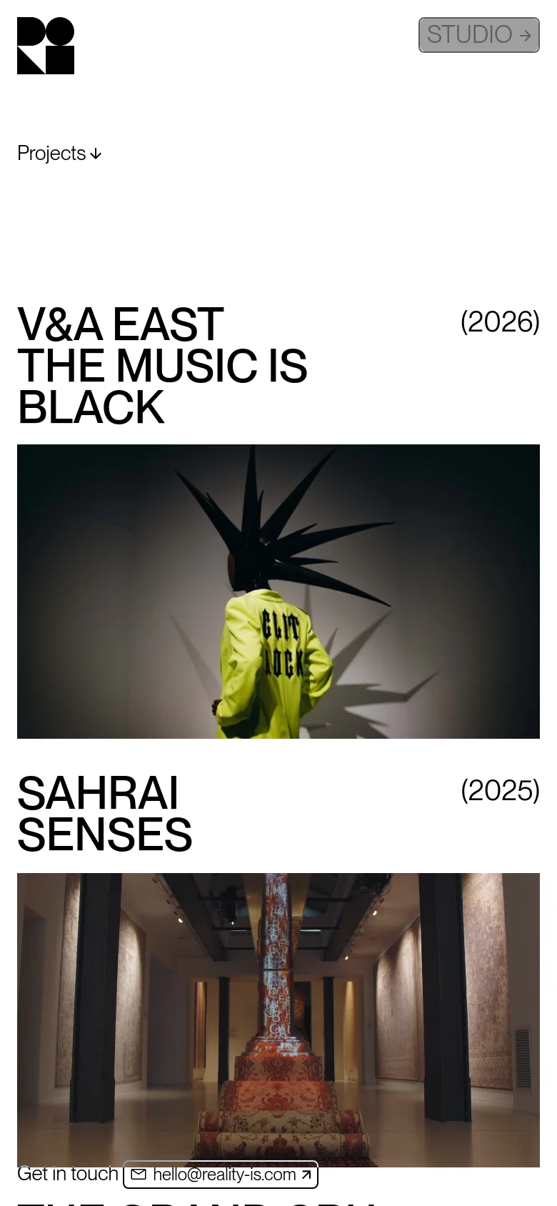 The mobile version maintains the minimalist black-on-white aesthetic but uses a more vertical, stacked layout. The large 'Reality is__' headline dominates the top, followed by a simplified navigation list and a vertical scroll of project entries featuring large images and bold titles.
