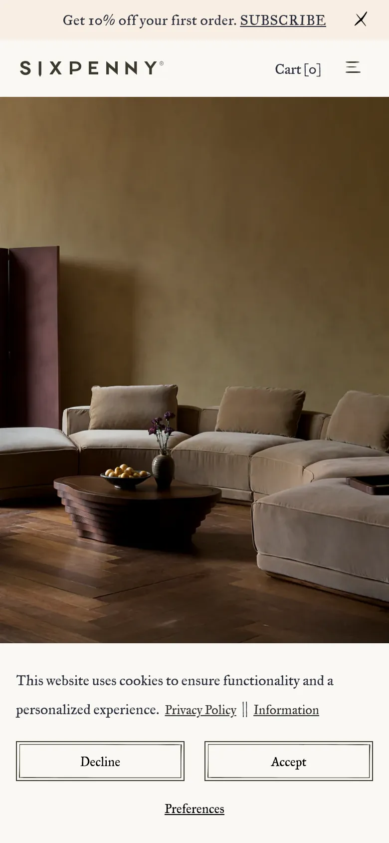 The mobile version simplifies the layout, replacing the full navigation bar with a hamburger menu icon and a centered brand logo. The hero image of the beige sofa remains the focal point, but the layout is vertically compressed to fit the smaller screen. A cookie consent banner with 'Decline', 'Accept', and 'Preferences' buttons is prominently displayed at the bottom.