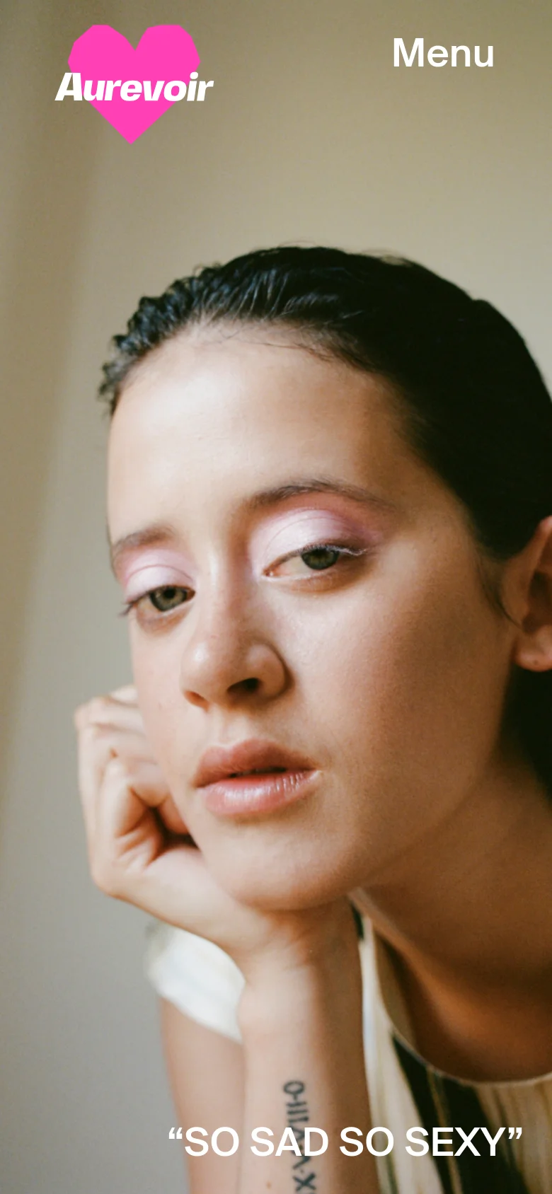 The mobile version displays a vertical, close-up portrait of a woman's face as the hero image, with the pink heart 'Aurevoir' logo in the top left and a large 'Menu' button in the top right. The headline 'SO SAD SO SEXY' is centered at the bottom of the screen, and the layout is optimized for a single-column vertical scroll.