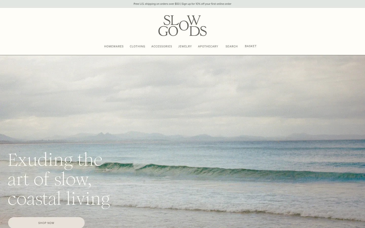 The desktop homepage features a minimalist design with a large hero image of a calm, coastal ocean scene under a cloudy sky. Centered over the image is the headline 'Exuding the art of slow, coastal living' and a 'SHOP NOW' button, with a top navigation menu including Homewares, Clothing, and Accessories. The color palette is muted and natural, dominated by soft blues, greys, and sandy tones.