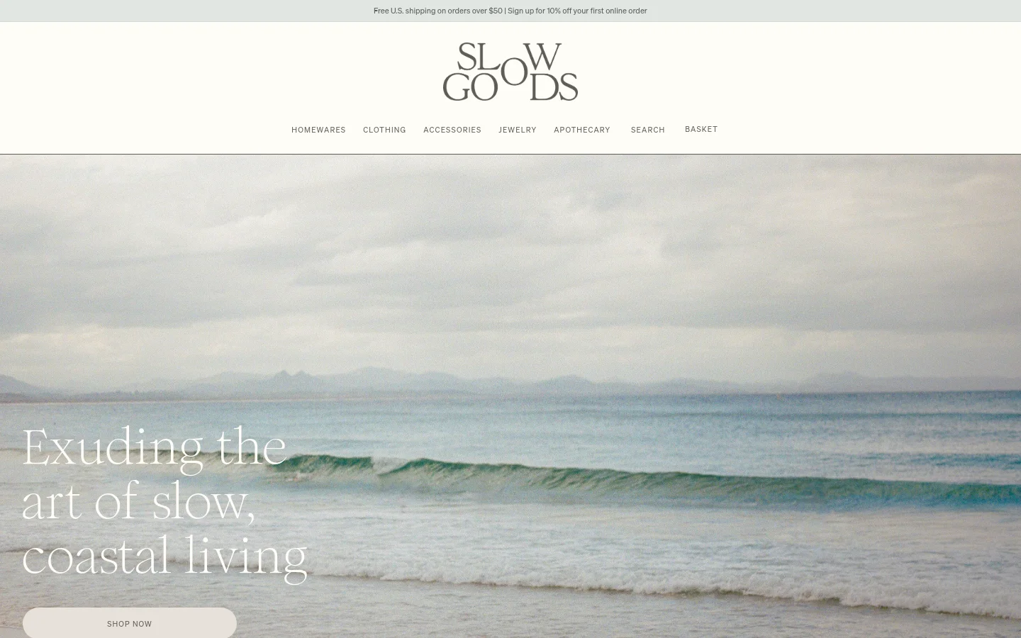 The desktop homepage features a minimalist design with a large hero image of a calm, coastal ocean scene under a cloudy sky. Centered over the image is the headline 'Exuding the art of slow, coastal living' and a 'SHOP NOW' button, with a top navigation menu including Homewares, Clothing, and Accessories. The color palette is muted and natural, dominated by soft blues, greys, and sandy tones.