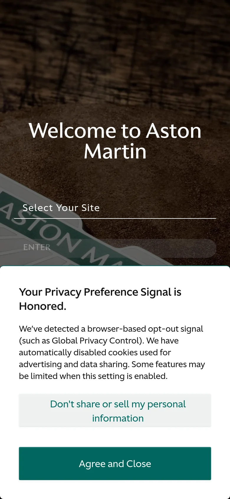 The mobile version shows the same winged emblem hero image, but the layout is vertically stacked with the 'Welcome to Aston Martin' headline appearing larger. A privacy preference pop-up overlay is visible at the bottom, featuring a white background with dark text and a prominent teal 'Agree and Close' button.